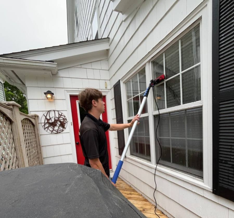 Glass N Shine technician using a water-fed pole to clean a second-story window